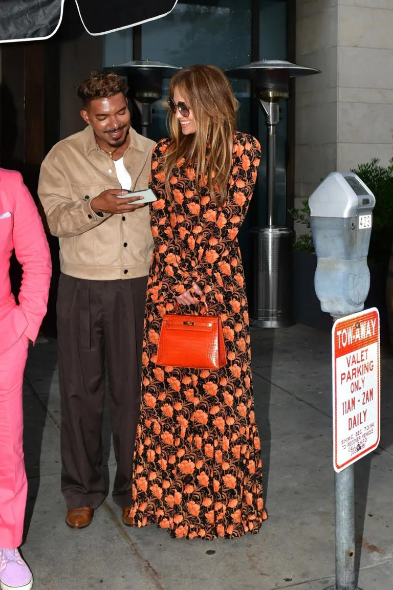 Lopez, 54, was seen celebrating in the black and orange floral dress from La Doublej, paired with an orange Hermès purse. BACKGRID