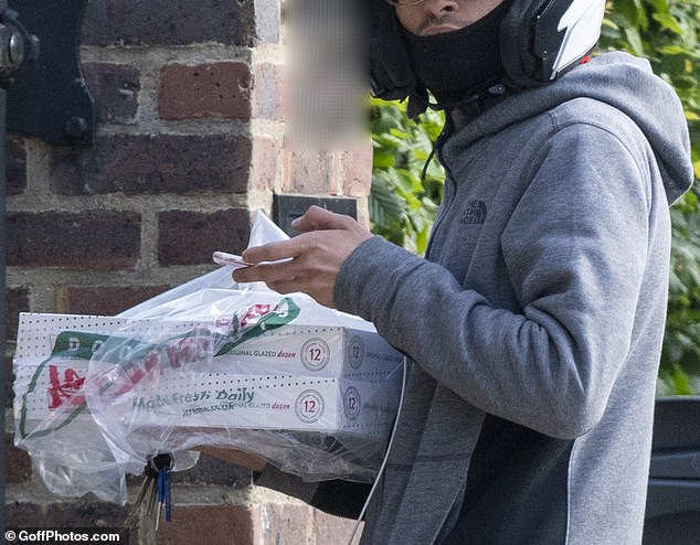 Hungry? The delivery driver was seen bringing two boxes of 12 Krispy Kreme doughnuts to the property for the family's low-key evening in